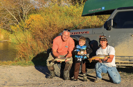 A man, woman, and child are standing next to a truck, holding fishing rods. AI generated content
