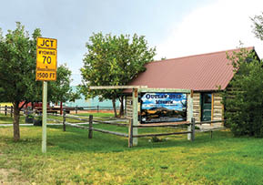 A sign is posted on a fence in front of a small building. AI generated content
