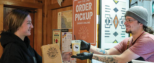 A man and woman are in a store, the man is holding a bag and the woman is holding a box. The man is wearing a hat and gloves. AI generated content